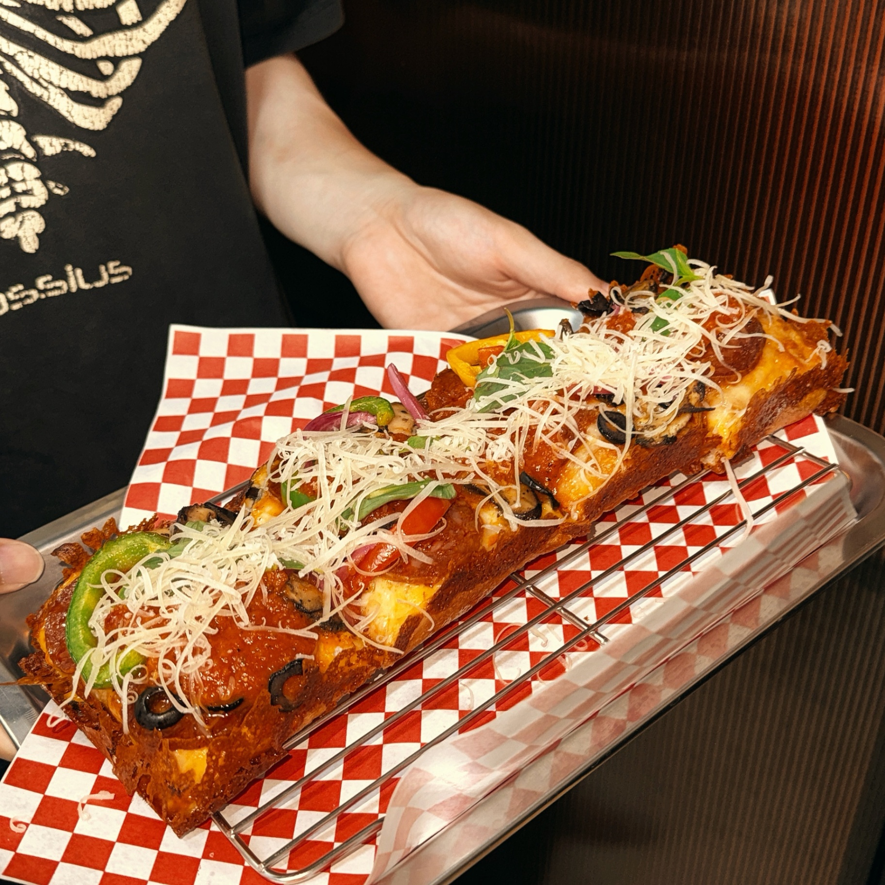 Supreme Clientele Detroit-style pizza held on a checkered tray