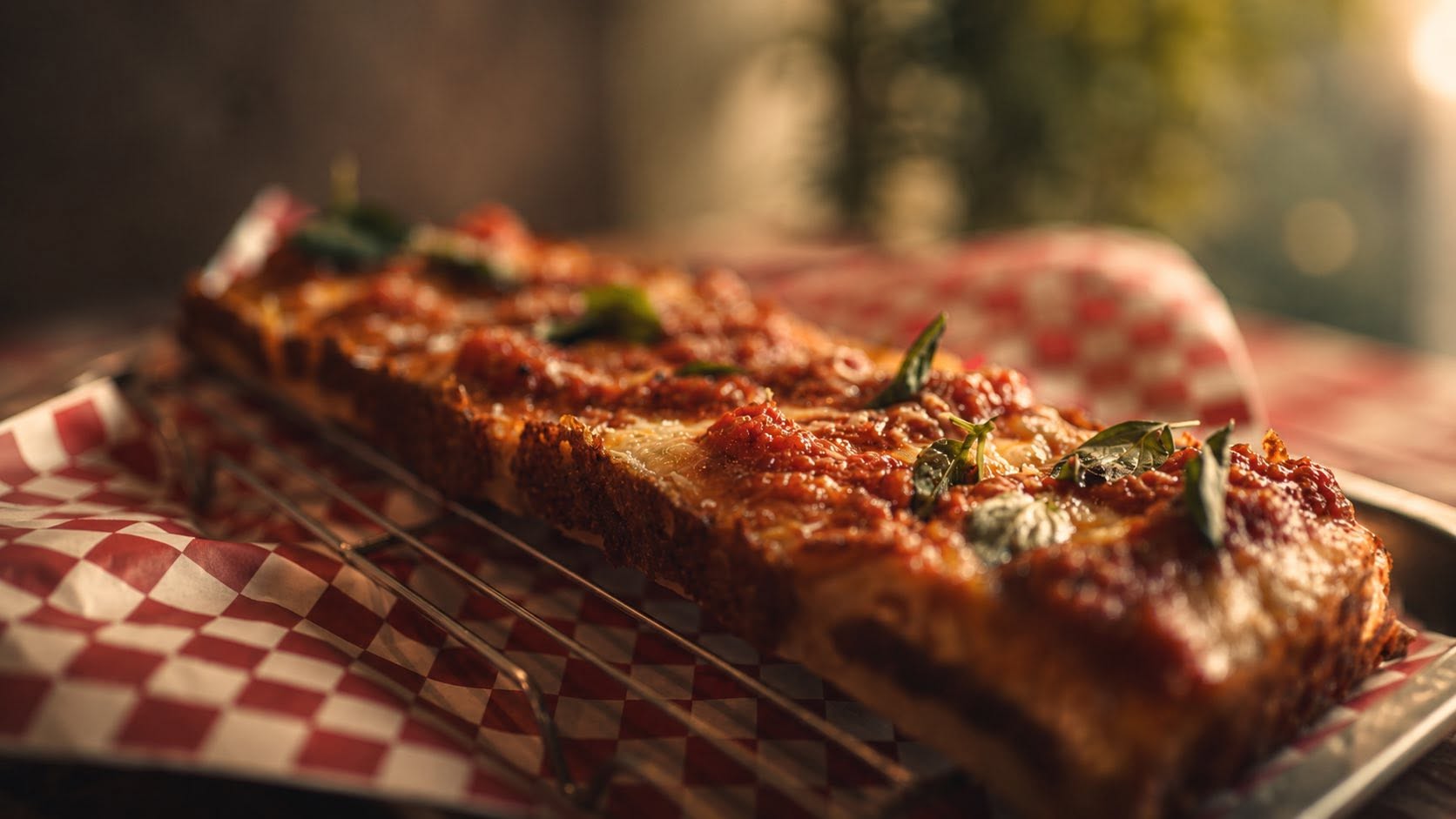 Alphabet City Detroit-style pizza served on red checkered paper in Chiang Mai